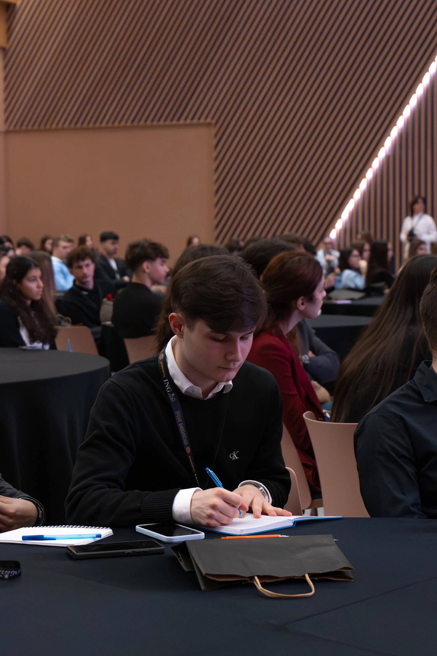 A FinMinds 2025 participant taking notes during a session
